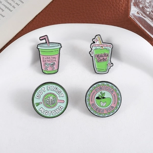 Set of 4 creative matcha green tea enamel pins in cute drink designs on ceramic plate