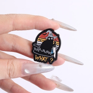 Close-up of black cat enamel pin with witch hat and knife for Halloween bags