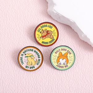Drei Emaille-Pins mit Cartoon-Hunden und lustigen Sprüchen auf rosa Ledergrund