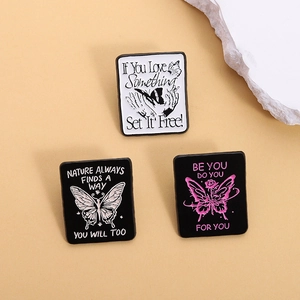 Three geometric butterfly enamel pins with inspirational quotes on a minimalist background