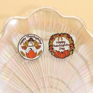 Macro detail of Thanksgiving enamel pins featuring turkey and pumpkin on glass shell plate