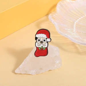 Detailed view of pug dog enamel pin with Christmas hat and red stocking accessory