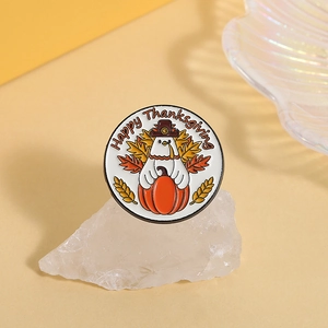 Macro detail of round enamel Thanksgiving pin with turkey, pumpkin and maple leaf motif