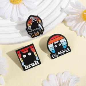 Detailed close-up of three black cat enamel pins on a white decorative display stand