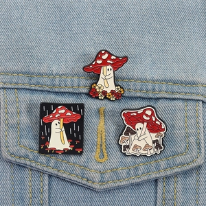 Three cute mushroom ghost enamel pins pinned on a light blue denim jacket pocket