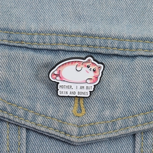 Cute fat cat enamel pin on blue denim jacket with 'Mother I Am But Skin And Bones' text