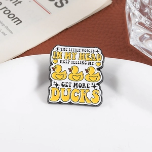 Detail of enamel duck brooch with humorous quote on a stylish ceramic plate