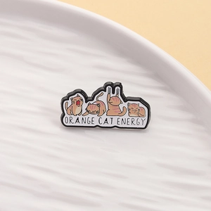 Detail of four cute cartoon orange cat enamel pins with Orange Cat Energy text