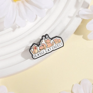 Detailed shot of Orange Cat Energy enamel pin with cute cartoon poses on white pedestal