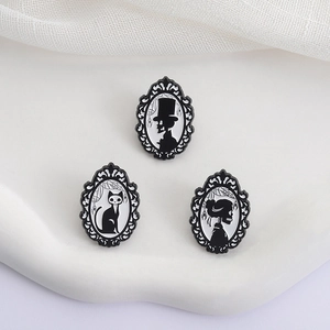 Gothic enamel pin set with skull portraits and black cat in Victorian frames