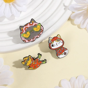 Detailed view of three cute cartoon cat enamel pins with floral outfits and sunglasses