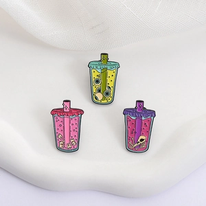 Detailed view of creative enamel pins featuring spooky boba tea cups with eye and bone motifs