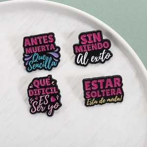 Set of four creative Spanish quote enamel pins with colorful text on black background
