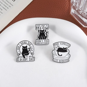 Whimsical black cat enamel pins set with humorous coffee quotes on white ceramic plate