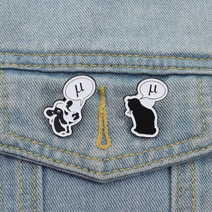 Cute enamel cow and cat pins with Greek letter mu detail on denim jacket pocket