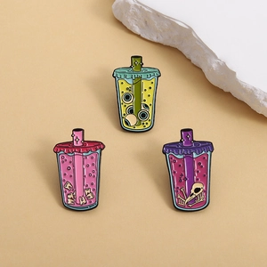 Quirky boba tea enamel pins featuring eyeball teeth and bird skull gothic charms