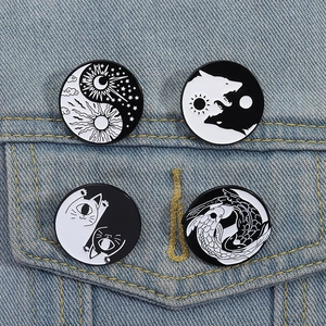 Set of four yin yang enamel pins featuring koi cats and celestial designs on denim