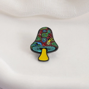 Artistic mushroom brooch with colorful spiral patterns on textured cream background