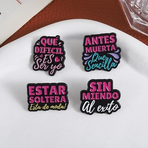 Set of four funny enamel pins with Spanish slogans on white ceramic plate jewelry display