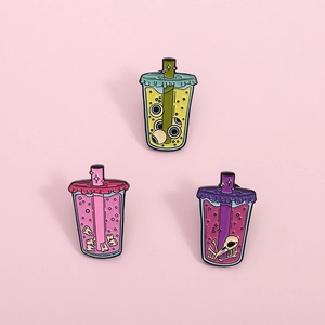 Spooky bubble tea enamel pins featuring cartoon eyeball, teeth, and bird skeleton designs