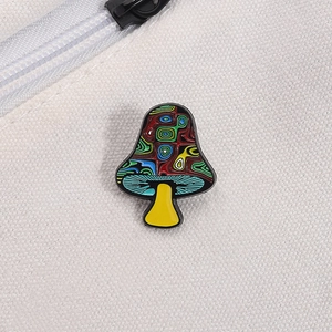 Macro shot of colorful psychedelic mushroom enamel pin on white canvas material