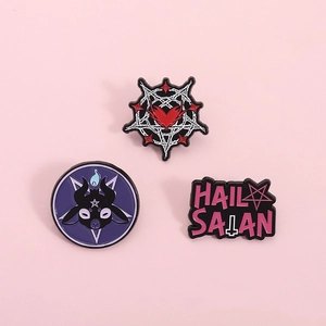Gothic enamel pin set with goat head and pentagram designs on a pink background