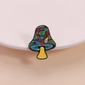 Artistic mushroom brooch with colorful swirl enamel pattern on a minimal beige podium
