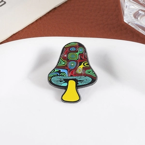 Artistic mushroom enamel pin with colorful psychedelic patterns on a white tray