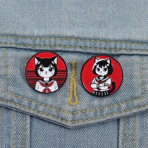 Set of two anime girl enamel pins in sailor suits on denim fabric texture