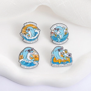 Détail de quatre broches dauphins en émail avec lunettes et slogans Fin-tastic stylés