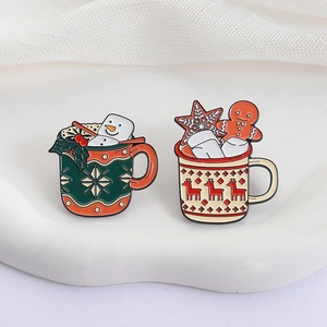 Christmas mug enamel pins with snowman and reindeer motifs on a white display stand