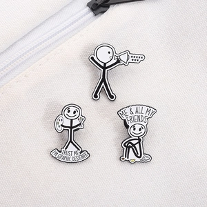Nahaufnahme minimalistischer Strichmännchen-Emaille-Pins an einer weißen Canvas-Tasche