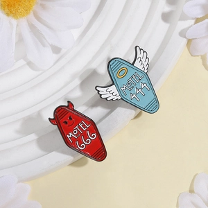Detail of red Devil Motel 666 and blue Angel Motel 444 enamel pin set on display