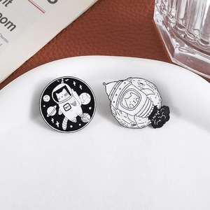 Cute astronaut cat enamel pins featuring a rocket and moon in a minimalist metal style
