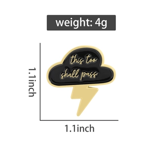 Detail of cloud and lightning enamel pin with 'this too shall pass' engraving