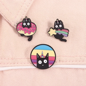 Détails de trois épingles en émail chat licorne noir avec donuts sur denim rose