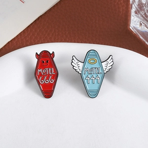 Creative devil 666 and angel 444 motel enamel pins set on a white ceramic plate