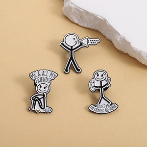 Three creative stickman enamel pins with humorous text on a minimalist beige background