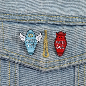 Creative devil and angel motel number enamel pins set on light blue denim jacket background