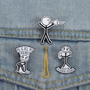 Minimalistische Emaille-Pins mit Strichmännchen-Motiv auf einer blauen Jeansjacke