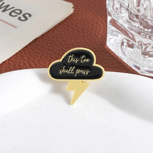 Enamel cloud and lightning brooch with 'this too shall pass' engraving in gold