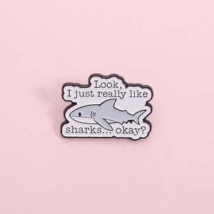 Cute gray shark enamel pin with funny quote on a soft pink background for clothing decor
