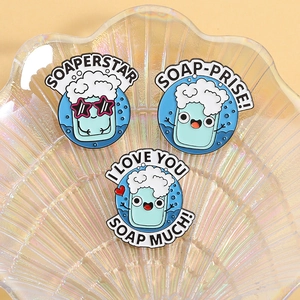 Lot de trois pin's en émail savon bleu avec jeux de mots rigolos sur plateau en verre