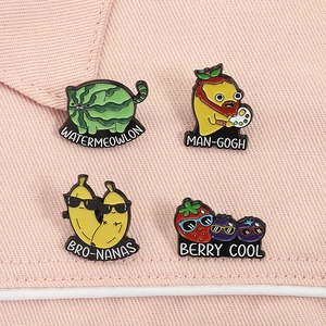 Detail shot of creative enamel fruit badges including watermelon cat and mango art