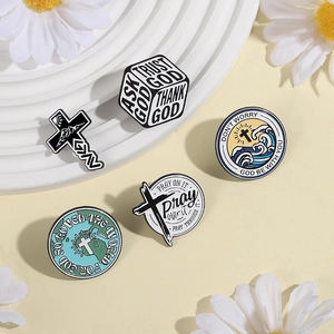 Detail of five religious enamel pins featuring crosses and inspirational prayer quotes