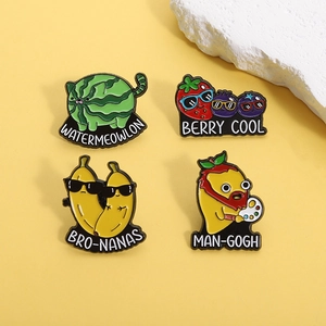 Set of four creative enamel pins with punny fruit animal designs on yellow backdrop