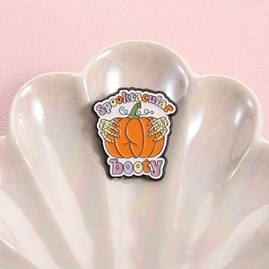 Halloween pumpkin skull hand enamel pin with Spooktacular booty text on shell tray