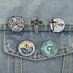 Set of 5 Christian enamel pins with cross and nature motifs on denim jacket pocket