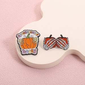 Halloween enamel pin set featuring skeleton hands holding pumpkins with Spooktacular booty text