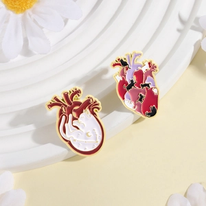 Détail macro de broches cœur de chat en émail avec motifs anatomiques félins